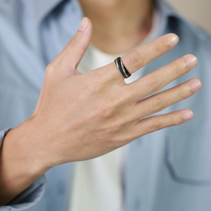 Detail of men's twill titanium steel ring in black and silver on male model's hand