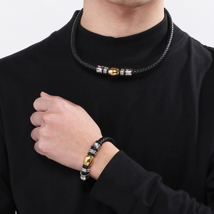 Détail d'un ensemble de collier et bracelet en cuir noir tressé avec perles métalliques