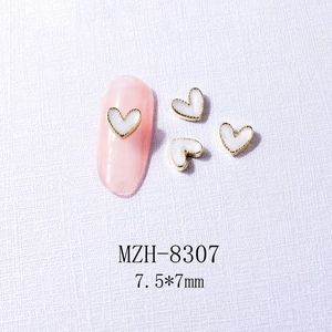 White heart nail charm with gold metal edge, size 7.5x7mm, on pink faux nails