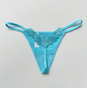 Close-up of light blue thong featuring intricate floral lace and 100% polyester fabric