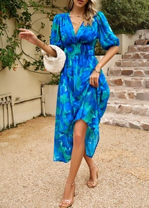 Détail d'une robe longue fleurie bleu-vert avec col en V et manches bouffantes en extérieur