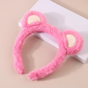 Detailed view of pink plush headband with cute animal ears on a white display stand