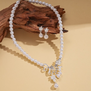 Elegant pearl necklace and earring set with diamond-encrusted floral leaf pendant