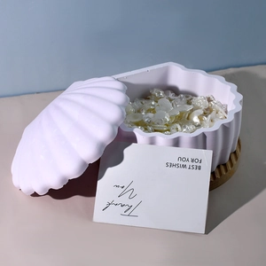 Vista macro de caja de joyería con forma de concha con tapa y perlas decorativas