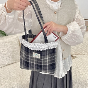 Detailed shot of the lace trim and happy patch on the plaid wool tote bag