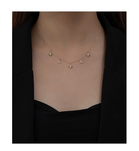 Close-up of gold star and moon pendant necklace with crystals on a black suit jacket