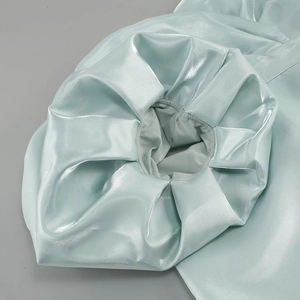 Detail of mint green satin puff sleeves with elastic shirring and glossy silk texture