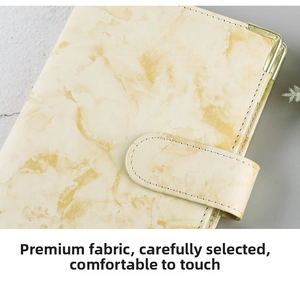 Detail of yellow marble texture PU leather binder with gold corners and magnetic closure