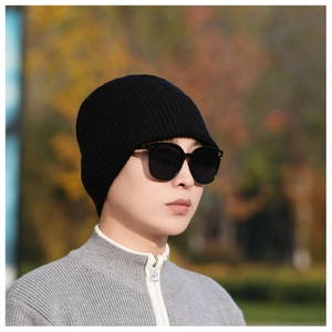Close-up of the black ribbed knit texture on a thick winter beanie for men