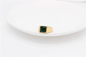 Close-up of a square green gemstone set in a polished gold titanium steel ring band