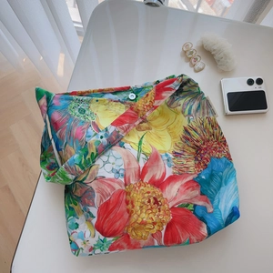 Detail of colorful floral cotton tote bag showing magnetic clasp and simple wish label