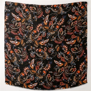 Detailed close-up of retro black paisley scarf featuring intricate boho patterns and fringe