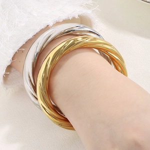 Close-up of twisted rope texture on gold and silver stainless steel minimalist bangles