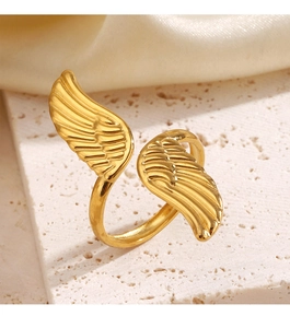 Detail of gold adjustable angel wing ring displayed on elegant stone and silk backdrop