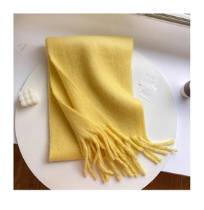 Detailed view of warm yellow mohair scarf with soft plush texture and elegant fringe