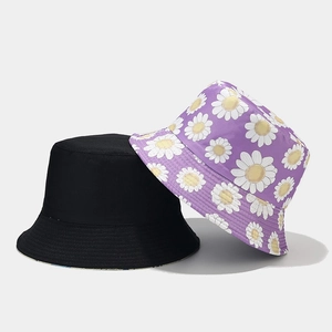 Vue détaillée d'un chapeau de soleil noir et d'un bob réversible violet à motif marguerites