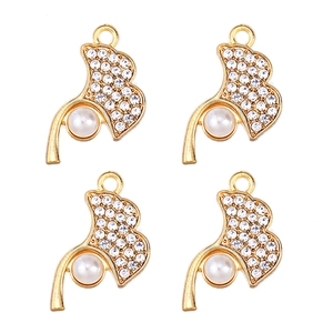 Detail of four golden ginkgo leaf pendants with sparkling rhinestones and white pearls