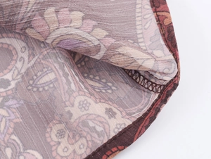 Close-up of bohemian paisley chiffon fabric with precision stitching and sheer texture