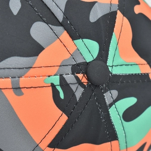 Close-up of camouflage cotton baseball cap top showing fabric texture and stitching
