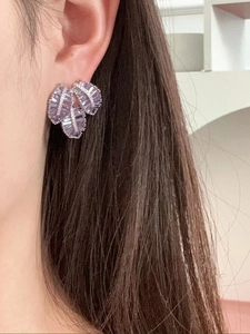 Detail of purple leaf-shaped zircon earrings with micro-inlaid silver finish on ear