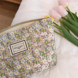 Detailed macro view of floral cotton pouch with zipper and Time to Party woven label