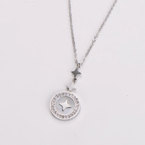 Close-up of silver steel necklace with shell inlay circular pendant and star detail
