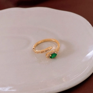 Vue détaillée de la bague serpent dorée avec gemme ovale verte et zircons incrustés