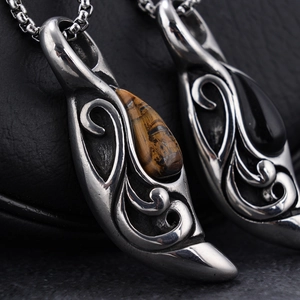 Nordic teardrop pendant necklaces with tiger eye and black onyx on leather background