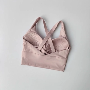 Détail du soutien-gorge de sport rose avec bretelles croisées et coussinets texturés