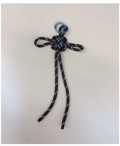 Close-up of hand-woven dark brown paracord keychain with reflective stripes and metal ring