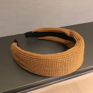 Detail of caramel wide knitted headband showing cross-stitch texture and black lining