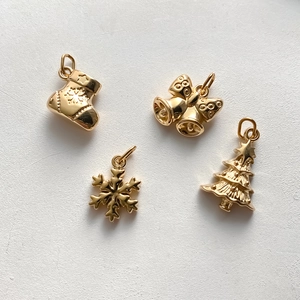 Detailansicht goldener Weihnachtsanhänger mit Socke, Glocke, Schneeflocke und Baum