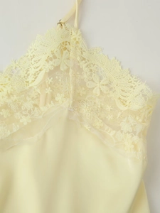 Gros plan détaillé du haut en satin jaune clair avec de la dentelle florale délicate