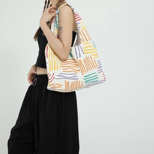 Colorful striped canvas tote bag with large capacity shown as a shoulder bag on model
