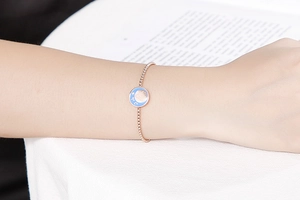 Bracciale a sfere oro rosa con ciondolo zodiacale in smalto blu indossato al polso
