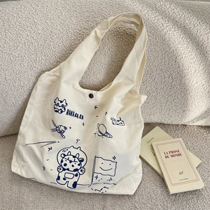 Detail of canvas tote bag showing astronaut cow print and snap button closure