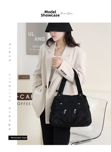 Close-up of black nylon tote bag with functional multiple zipper pockets and wide strap