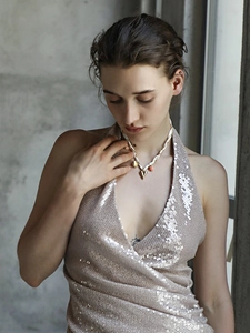 Dettaglio dei ciondoli a cuore e fiore placcati in oro 18K su collana di cordoncino bianco