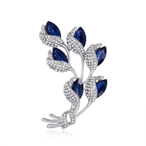 Macro detail of luxury silver brooch with deep blue marquise gems and clear crystals
