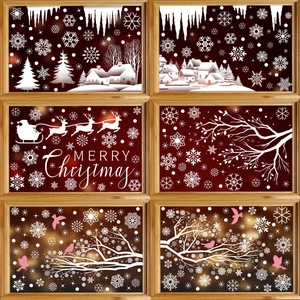 Christmas window decals with white snowflakes, reindeer and snow house on glass panes