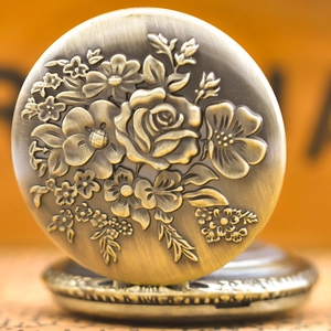 Close-up of vintage bronze quartz pocket watch with embossed rose flower design