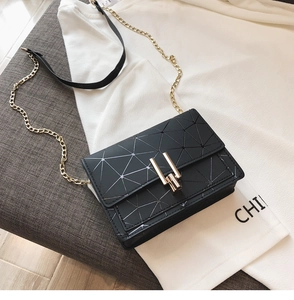 Detail of black mini crossbody bag featuring geometric lines and gold buckle closure