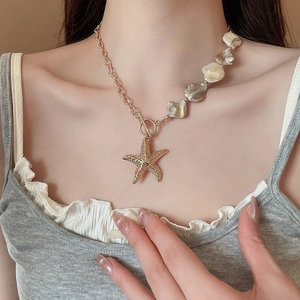 Detail of starfish pendant necklace with asymmetric pearl chain and OT toggle clasp