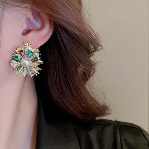 Detail of vintage flower earrings with crystals and pearl on a model's ear