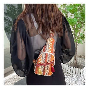 Detailed back view of an ethnic woven crossbody bag with colorful tassels and jacquard strap