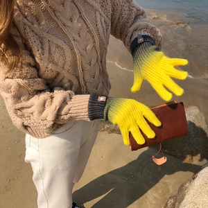 Detail of gradient knitted touchscreen gloves with grey cuffs and yellow fingertips