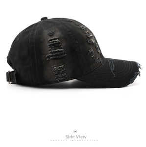 Detail view of the distressed washed cotton fabric and side fraying on the black baseball cap