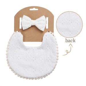 Detail of white cotton baby bib set with floral embroidery and lace trim on card