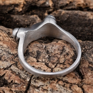 Men's stainless steel ring with brushed texture finish on a natural wood surface