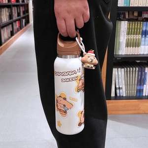 White Capybara thermal bottle with brown lid and mascot keychain held in hand